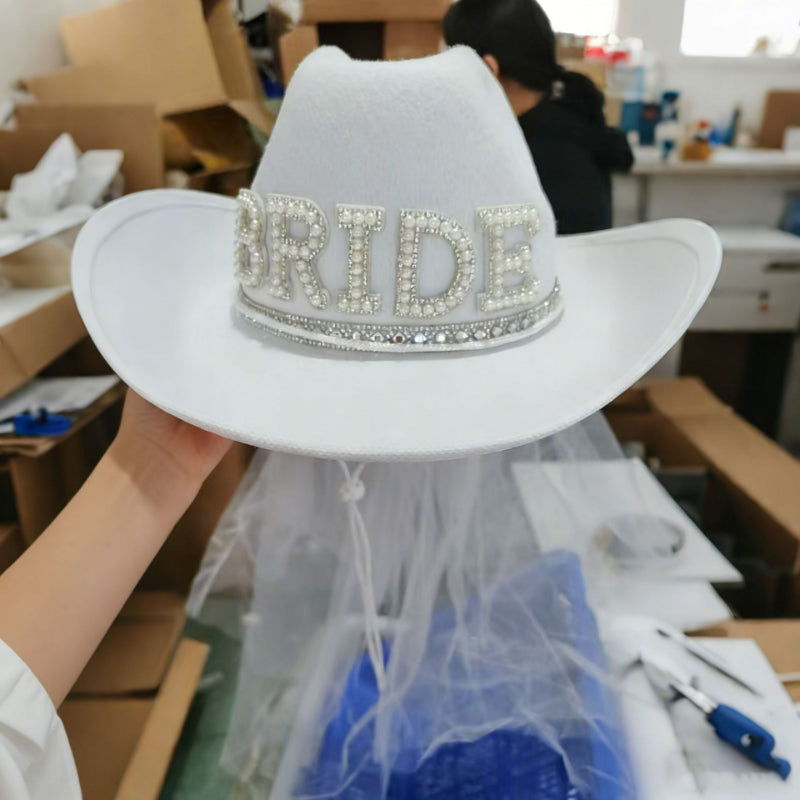 White bride cowboy hat with veil close-up product photo in workshop