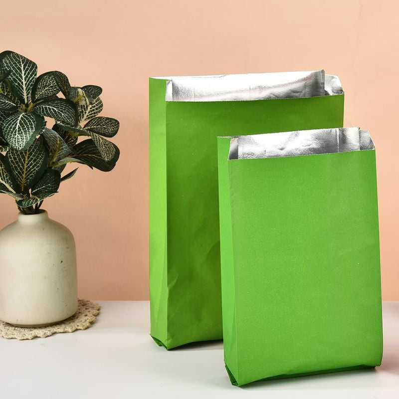 Foil-lined takeout bag green exterior with two upright sizes showing side gusset and silver interior