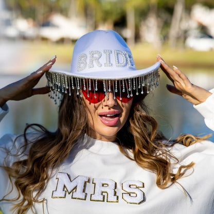 White bride cowboy hat with rhinestone fringe trim worn by bride