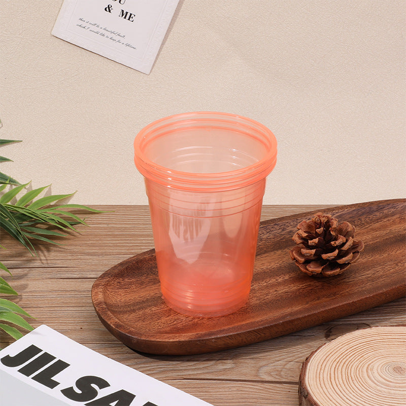 Colored disposable plastic party cups in pink green blue and orange