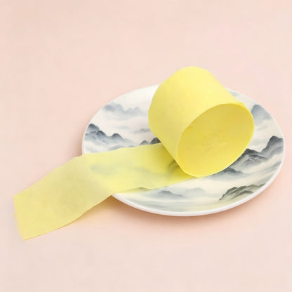 Crepe paper streamer pale yellow coiled roll extending strip