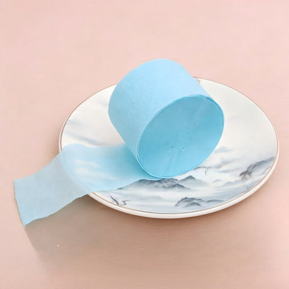 Crepe paper streamer light blue coiled roll extending strip
