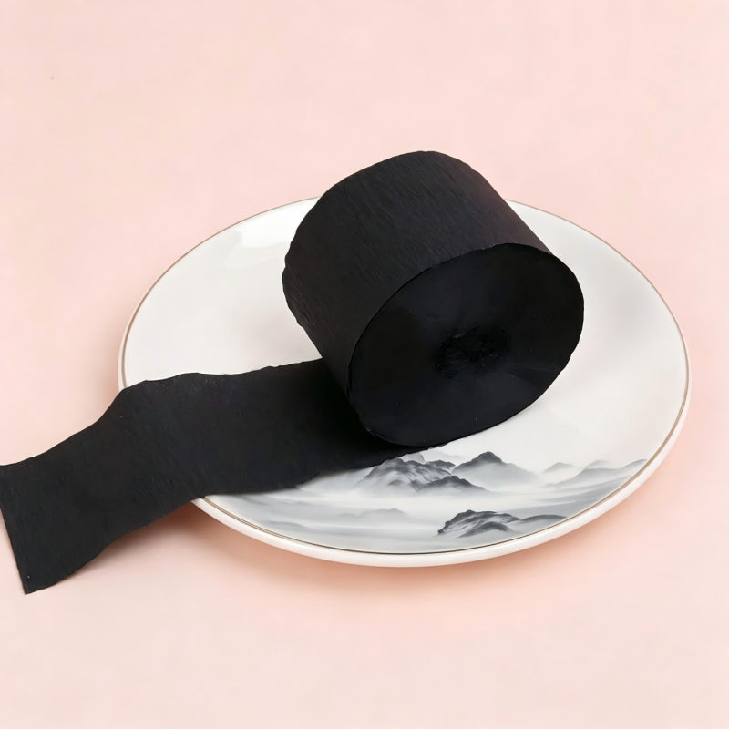 Crepe paper streamer solid black compact roll unrolled ribbon