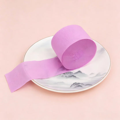 Crepe paper streamer rose purple coiled roll extending stri