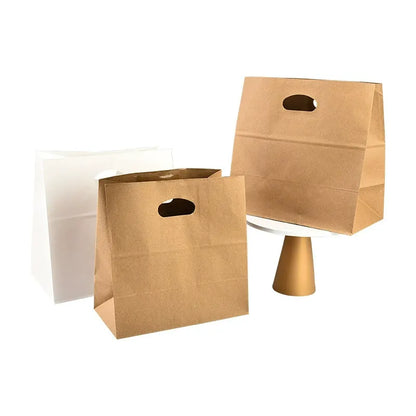 Die-cut kraft bag natural brown and white takeout sacks standing upright with oval punch handles