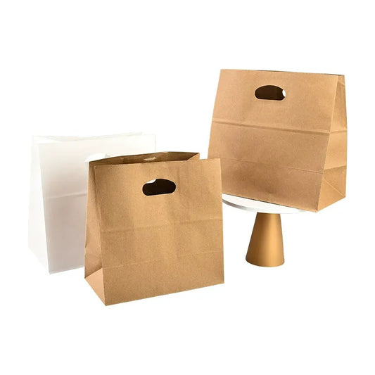 Die-cut kraft bag natural brown and white takeout sacks standing upright with oval punch handles