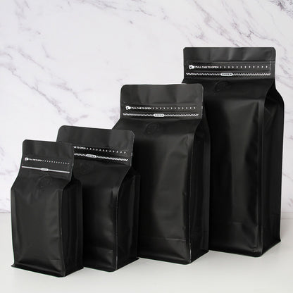Coffee valve bag matte black four capacity graduating lineup showing front degassing valve and zipper