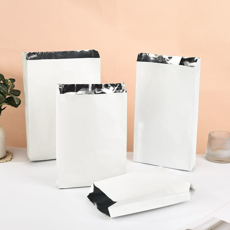 Foil-lined takeout bag clean white exterior with multiple upright sizes and folded base showing foil lining