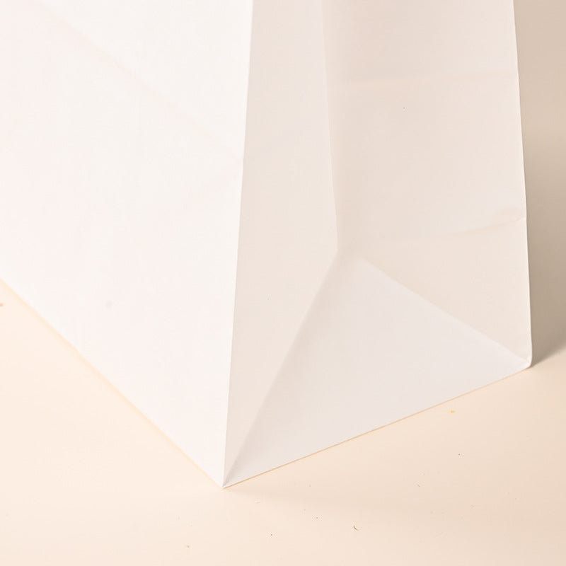 White kraft bag angled close-up view showing crisp side gusset crease fold
