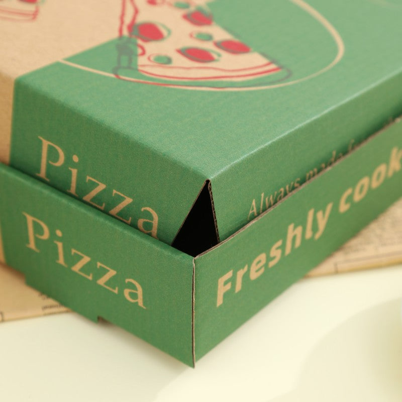 Printed pizza boxes stacked with green lids closed